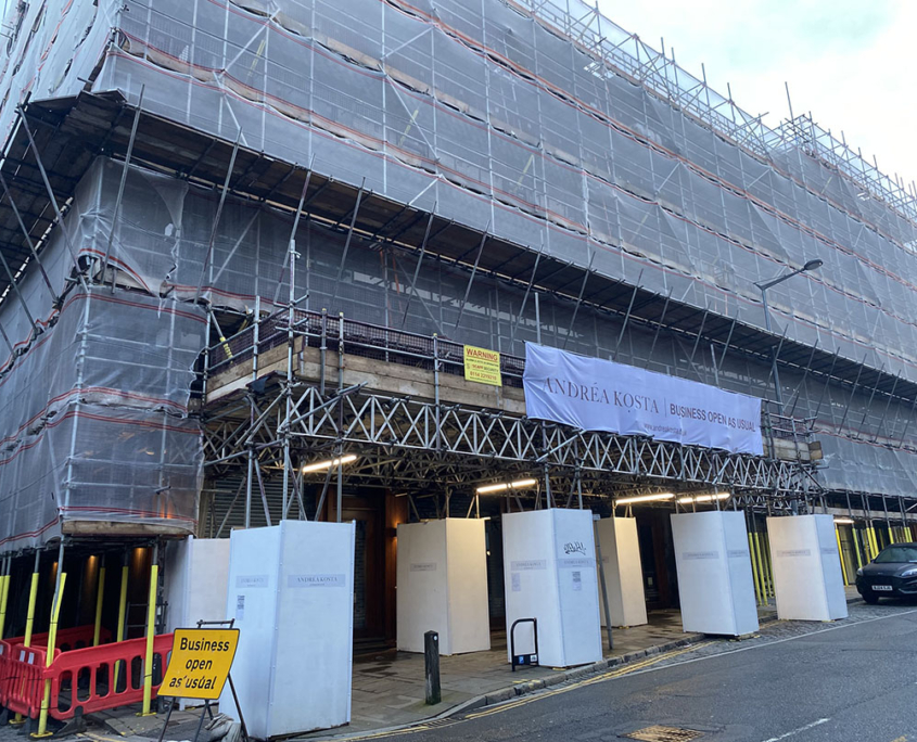 Scaffolding structure built above low-level roof with support framework